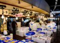 A vibrant scene at the Tsukiji Fish Market showcasing fresh seafood and active vendors in Tokyo, Japan.