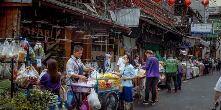 Vibrant street market scene in Asia with diverse vendors selling fresh produce.